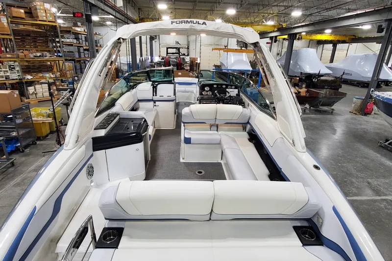  Yacht Photos Pics 2020 Formula 310 Bowrider boat interior in a warehouse, featuring spacious seating and modern design.
