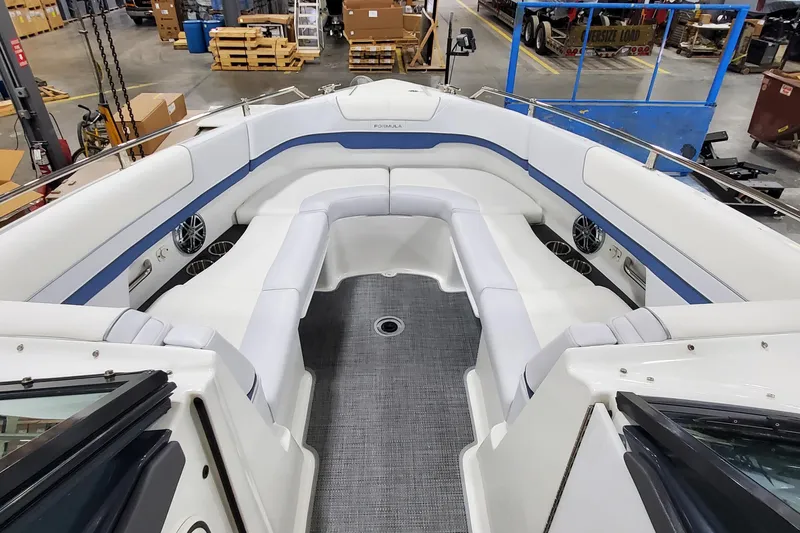  Yacht Photos Pics 2020 Formula 310 Bowrider interior with white seating and blue accents in a warehouse setting.