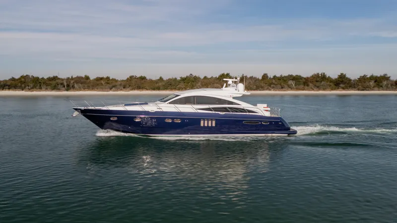 Endless Summer Yacht Photos Pics 2006 Princess V65 yacht cruising on calm waters near a scenic shoreline.