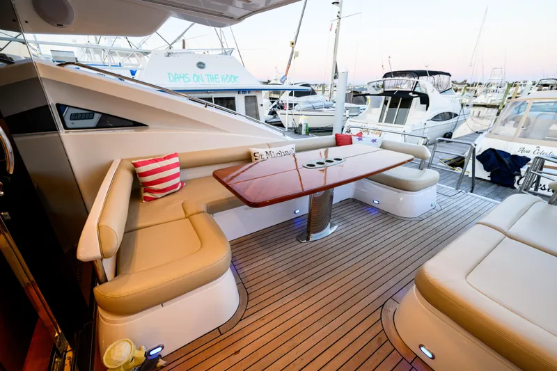 Endless Summer Yacht Photos Pics Luxurious 2006 Princess V65 yacht deck with elegant seating and table, docked at marina.