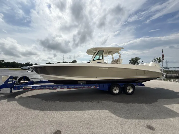  Yacht Photos Pics 2021 Boston Whaler 350 Outrage boat on trailer under cloudy sky.