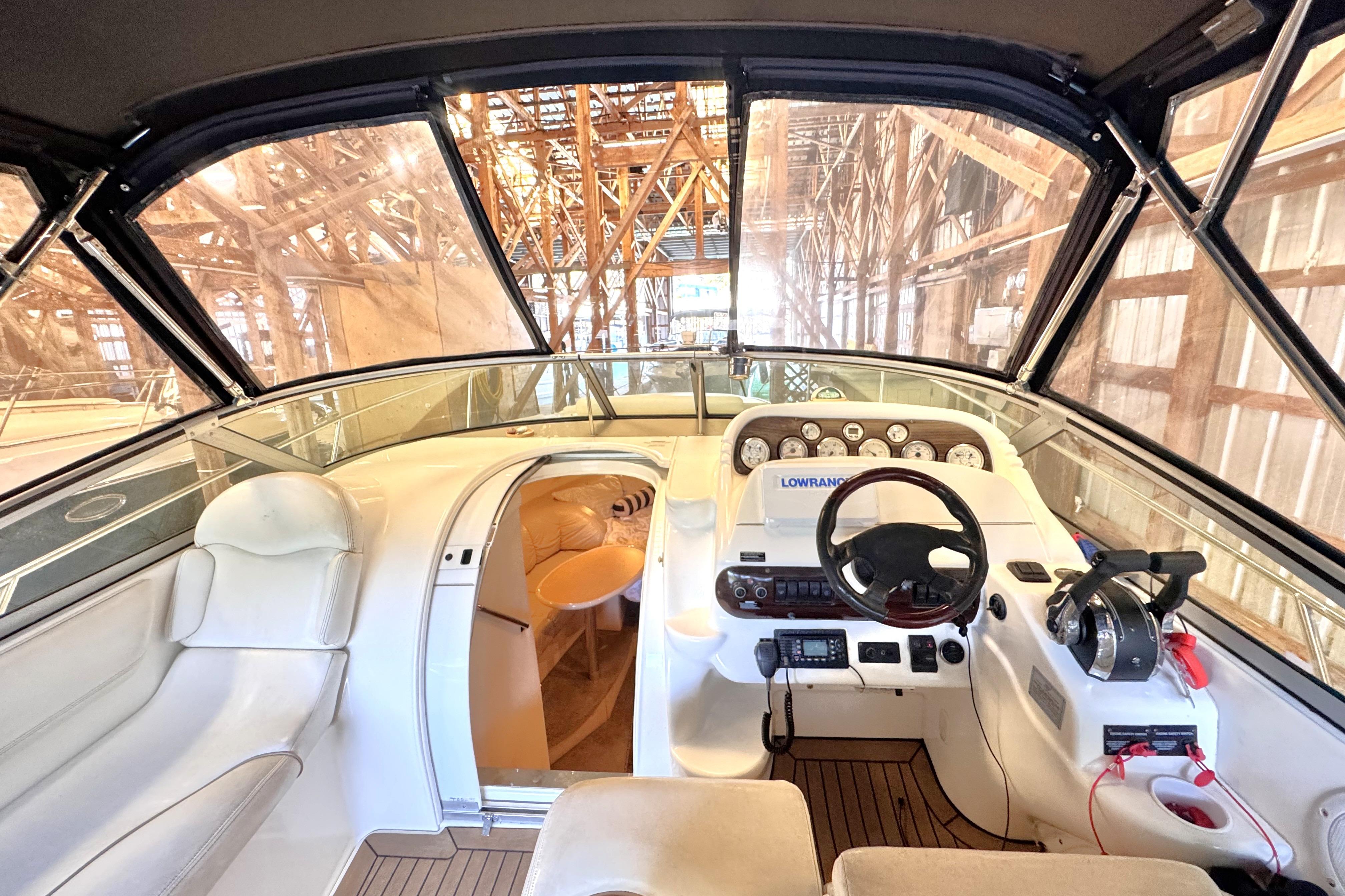 2002 Larson Cabrio 310 boat interior with helm, steering wheel, and cabin view.