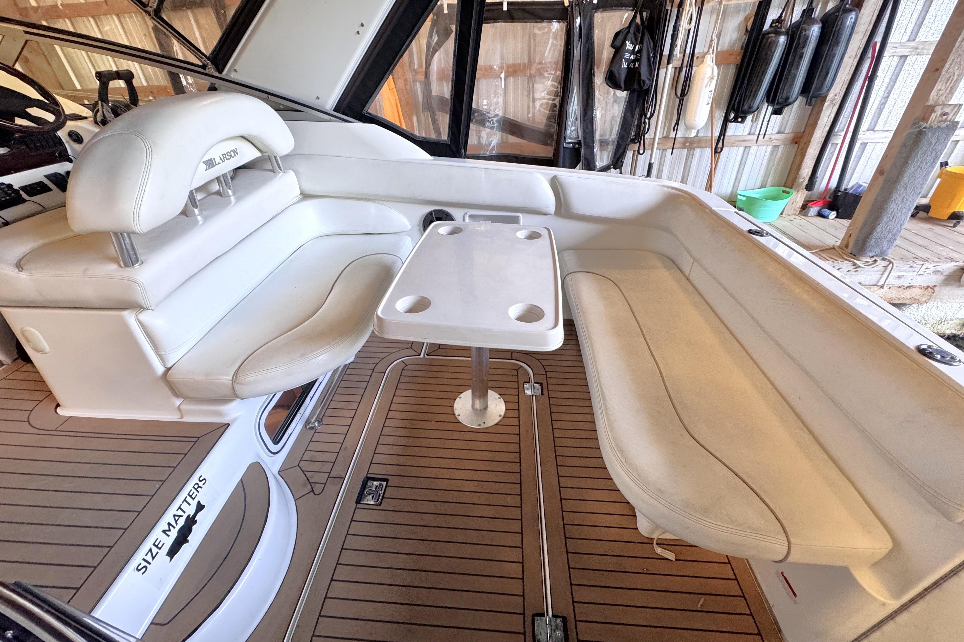 2002 Larson Cabrio 310 boat interior with white seating and wooden flooring.
