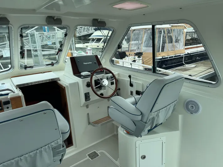 Change Of Pace Yacht Photos Pics 2008 Back Cove 29 Hardback boat interior with steering wheel and navigation equipment.