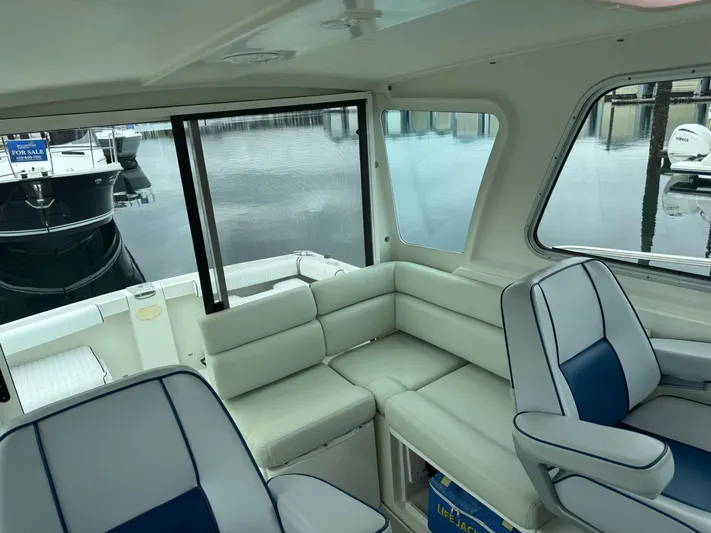 Change Of Pace Yacht Photos Pics 2008 Back Cove 29 Hardback interior with cushioned seating and marina view.