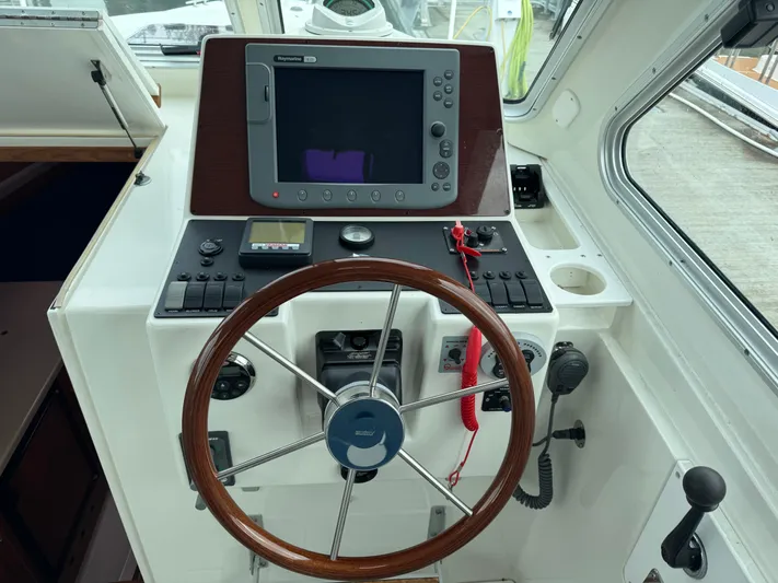 Change Of Pace Yacht Photos Pics 2008 Back Cove 29 Hardback helm with steering wheel and navigation controls.