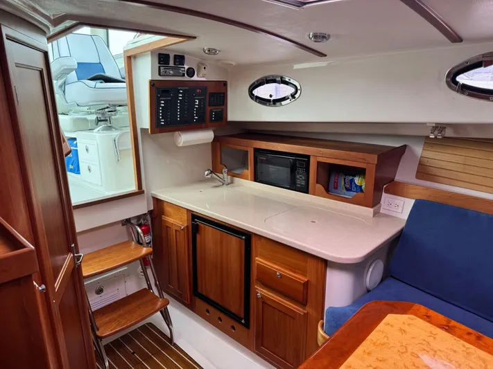 Change Of Pace Yacht Photos Pics Interior of 2008 Back Cove 29 Hardback boat with kitchenette and seating area.