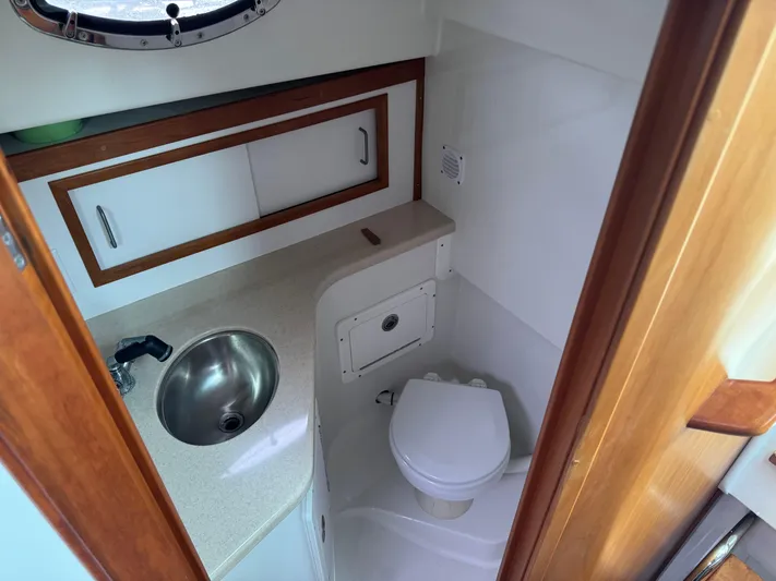 Change Of Pace Yacht Photos Pics 2008 Back Cove 29 Hardback boat bathroom with sink, toilet, and storage cabinets.