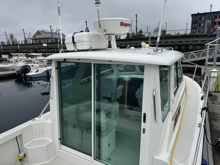 Change Of Pace Yacht Photos Pics 2008 Back Cove 29 Hardback boat docked, featuring a glass-enclosed cabin and Raymarine radar.