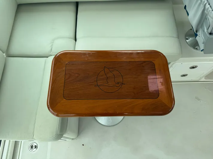 Change Of Pace Yacht Photos Pics 2008 Back Cove 29 Hardback boat interior with wooden table and cushioned seating.