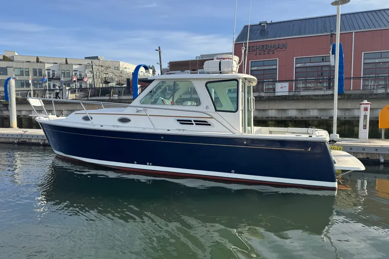 Change Of Pace Yacht Photos Pics 2008 Back Cove 29 Hardback boat docked at marina, blue hull, white cabin.