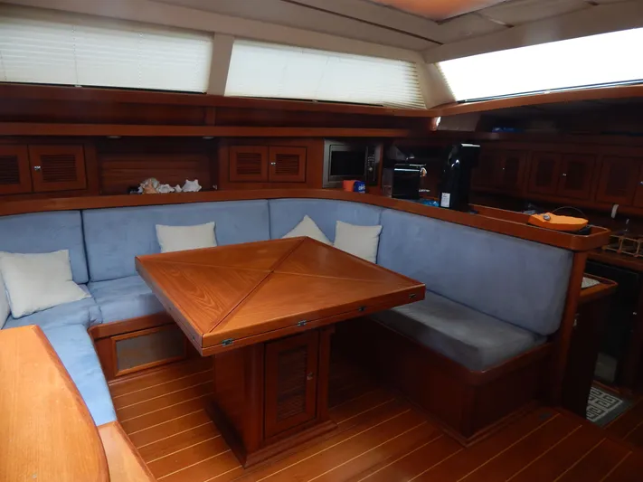  Yacht Photos Pics Luxurious interior of 2002 North Wind 58 yacht with wooden dining area and blue cushions.