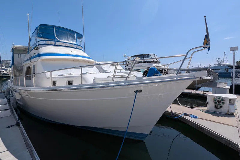 Fisher Folly IV Yacht Photos Pics 1988 Offshore Yachts 48 Yachtfisher docked at marina under clear blue sky.