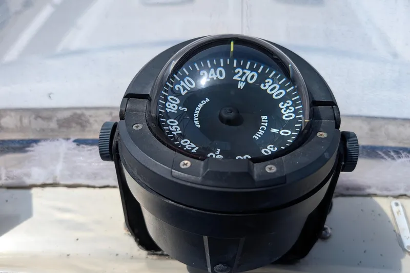 Fisher Folly IV Yacht Photos Pics Compass on 1988 Offshore Yachts 48 Yachtfisher, displaying navigational directions.