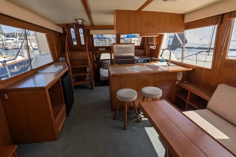 Fisher Folly IV Yacht Photos Pics Interior of 1988 Offshore Yachts 48 Yachtfisher with wooden furnishings and kitchen area.