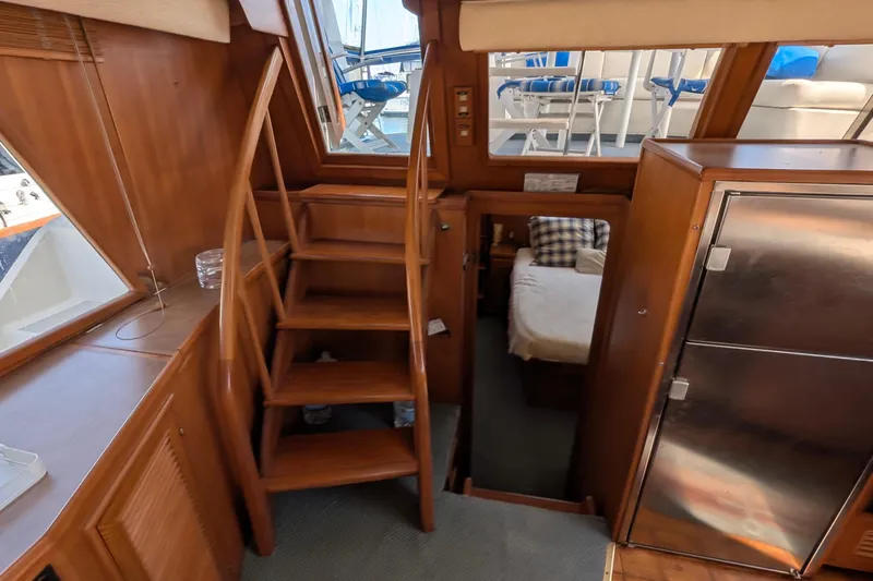 Fisher Folly IV Yacht Photos Pics Interior of 1988 Offshore Yachts 48 Yachtfisher with wooden stairs and cozy cabin.