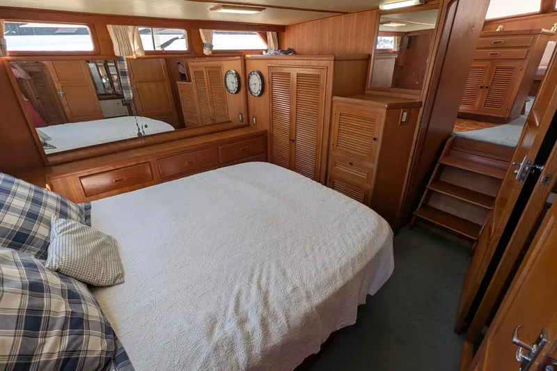 Fisher Folly IV Yacht Photos Pics 1988 Offshore Yachts 48 Yachtfisher cabin with wood paneling, bed, and nautical decor.