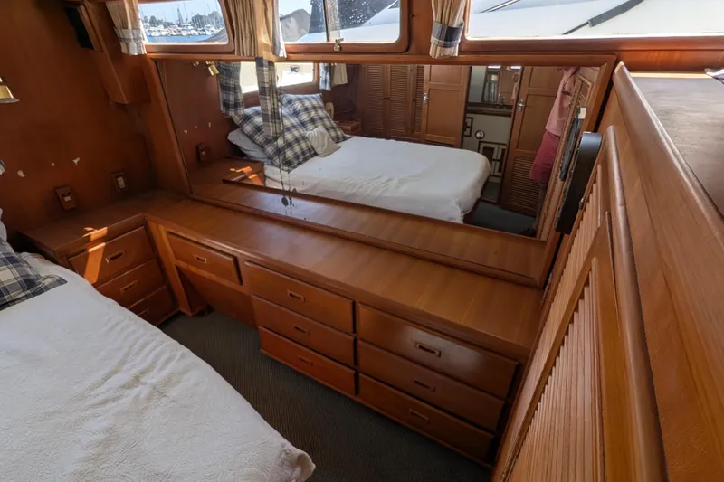 Fisher Folly IV Yacht Photos Pics Interior of 1988 Offshore Yachts 48 Yachtfisher, featuring wood cabinetry and cozy sleeping area.
