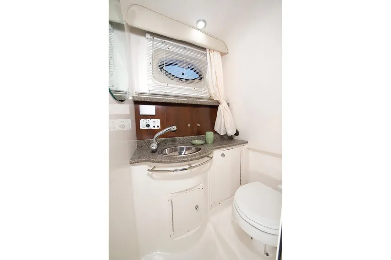  Yacht Photos Pics Manufacturer Provided Image: 2015 Robalo R305 Walkaround boat bathroom with sink, toilet, and porthole window.