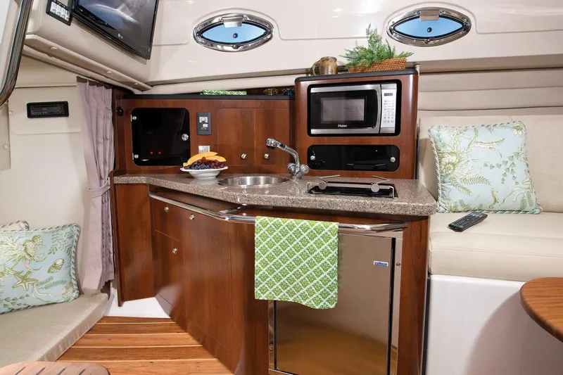  Yacht Photos Pics Manufacturer Provided Image: 2015 Robalo R305 Walkaround boat interior kitchen with microwave, sink, and seating area.