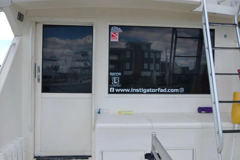  Yacht Photos Pics 1999 Viking 45 Convertible boat with ladder and window decals at a marina.