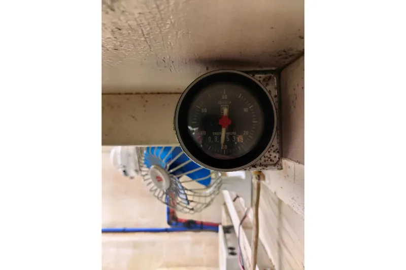  Yacht Photos Pics Engine hour meter on 1999 Viking 45 Convertible boat, with fan in background.