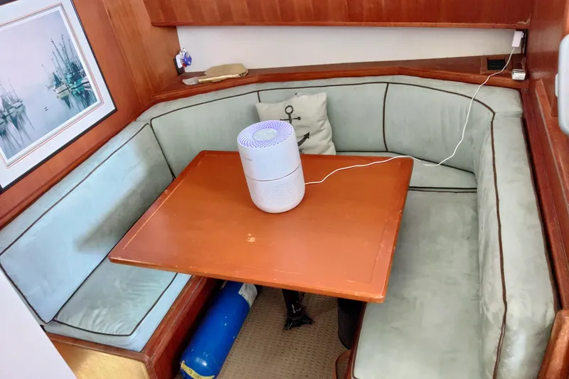  Yacht Photos Pics Cozy dining area in a 1999 Viking 45 Convertible yacht with a wooden table and cushioned seating.