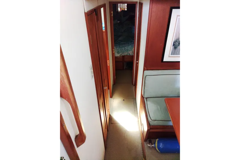  Yacht Photos Pics Interior hallway of 1999 Viking 45 Convertible yacht with wood paneling and seating area.