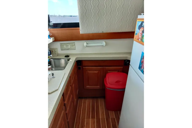  Yacht Photos Pics 1999 Viking 45 Convertible yacht kitchen with wooden cabinets and red trash bin.