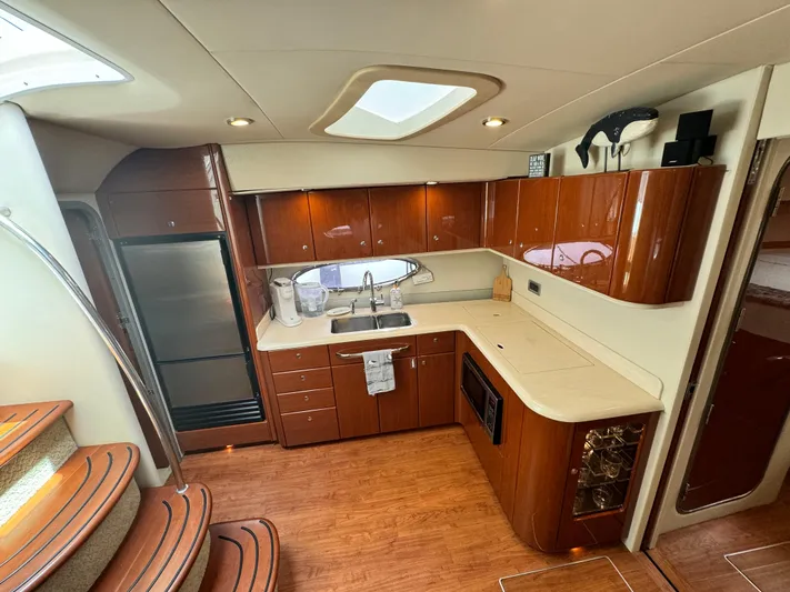 Lovely Day Yacht Photos Pics Luxurious kitchen interior of 2009 Formula 45 Yacht with wood cabinetry and modern appliances.