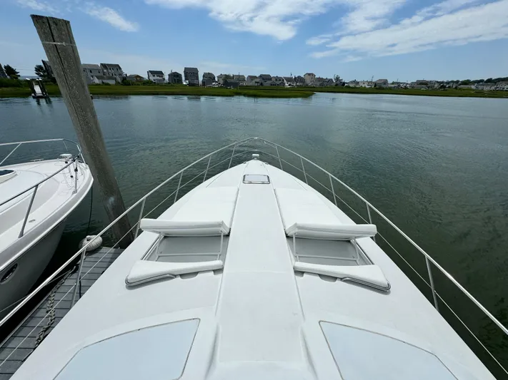 Lovely Day Yacht Photos Pics 2009 Formula 45 Yacht docked by serene waterfront under blue sky.