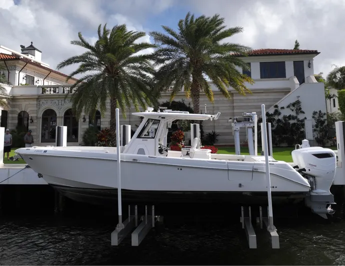  Yacht Photos Pics 2013 Everglades 325 Center Console boat docked near luxury waterfront home with palm trees.