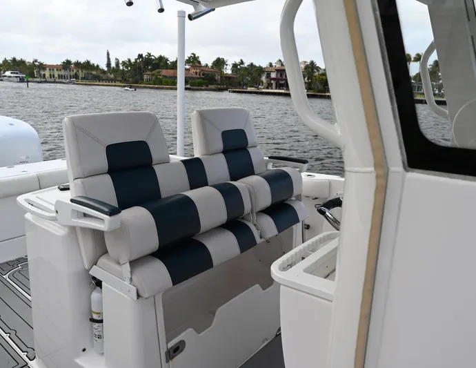  Yacht Photos Pics 2013 Everglades 325 Center Console boat interior with striped seating, on a calm waterway.