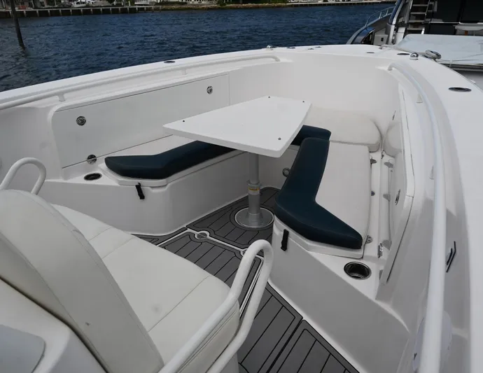  Yacht Photos Pics 2013 Everglades 325 Center Console boat with seating and table on deck.