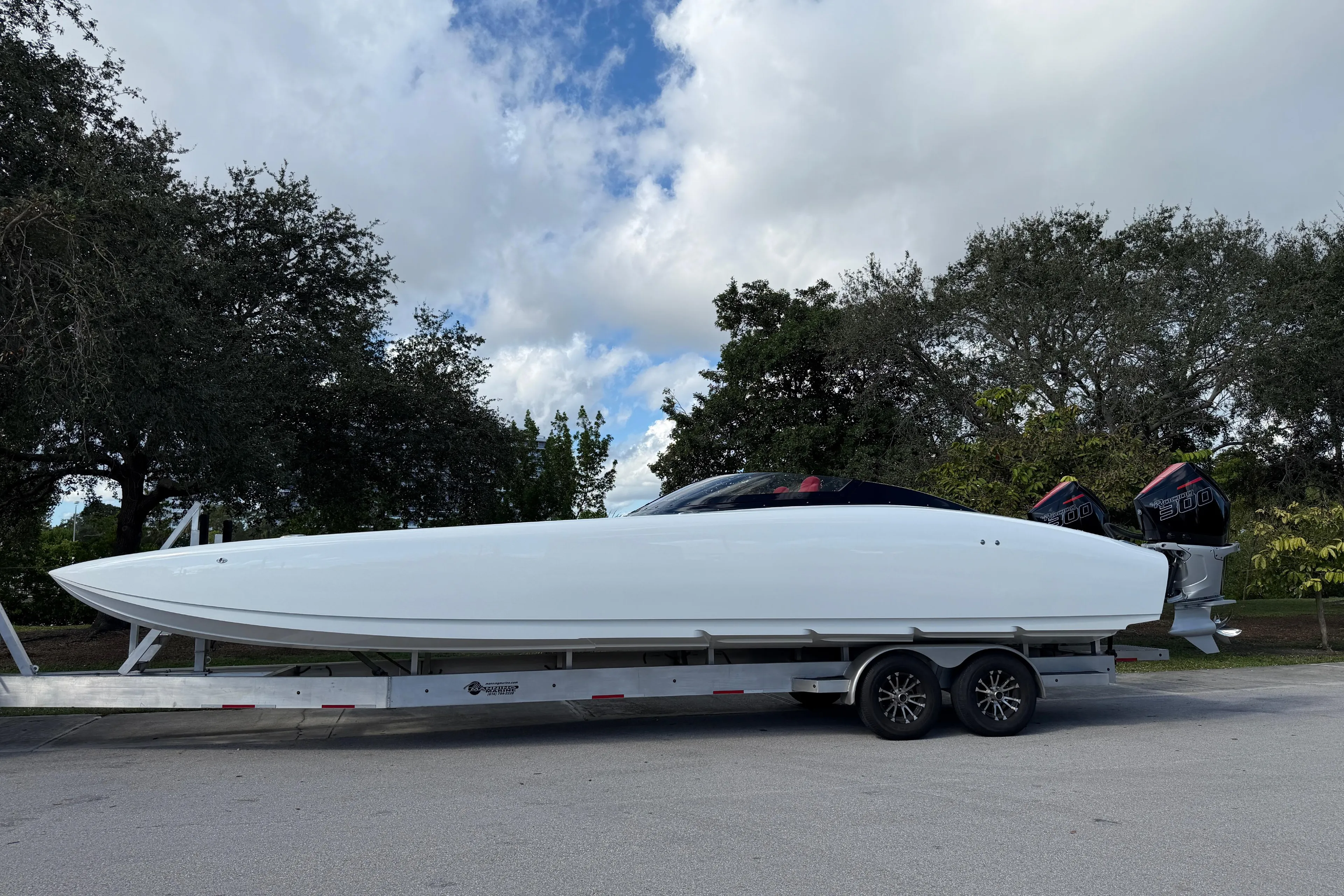 2022 Doug Wright 320 powerboat on trailer, parked outdoors under cloudy sky.