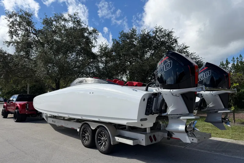  Yacht Photos Pics 2022 Doug Wright 320 powerboat on trailer with twin engines, parked near trees.