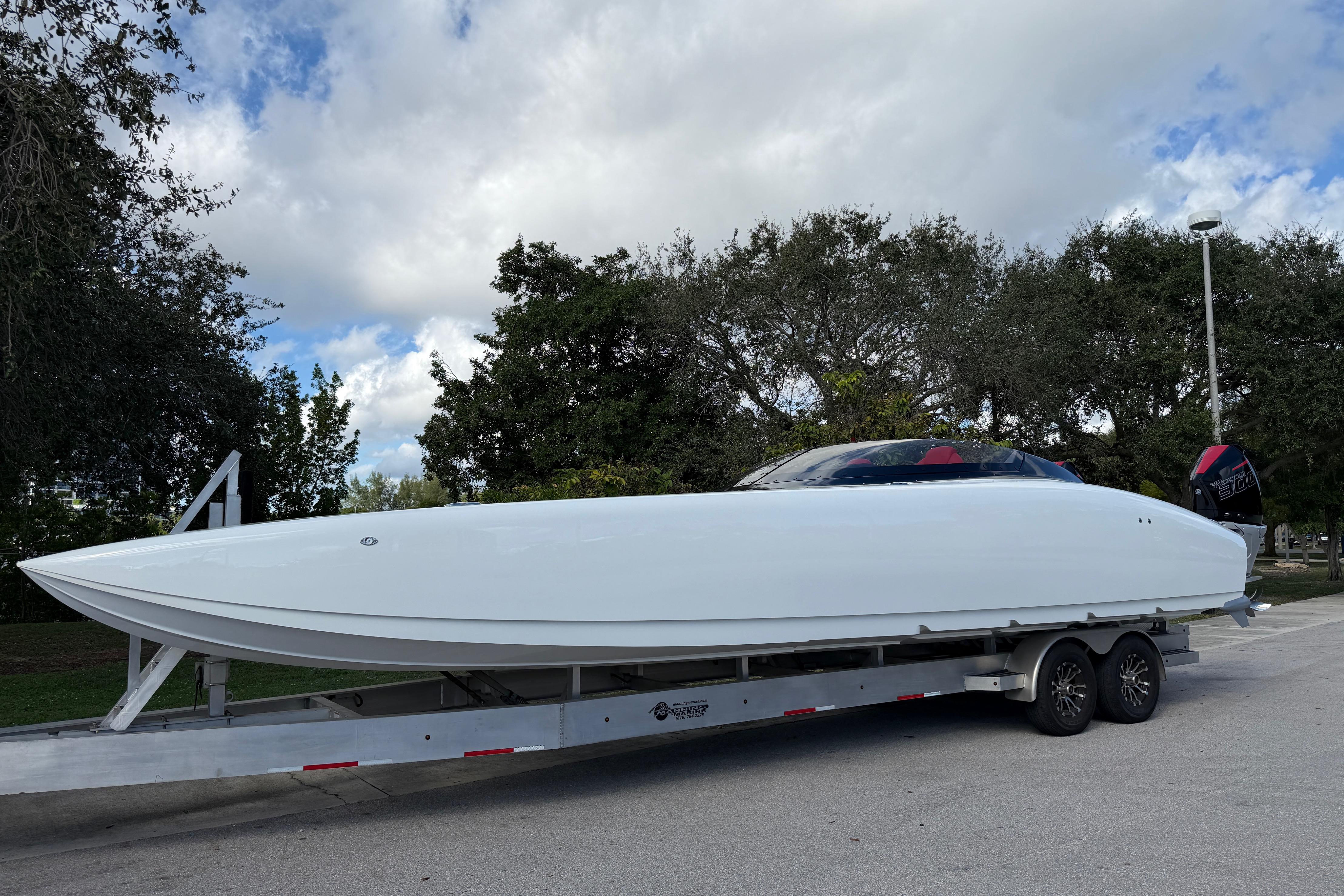 2022 Doug Wright 320 powerboat on trailer, parked outdoors under cloudy sky.