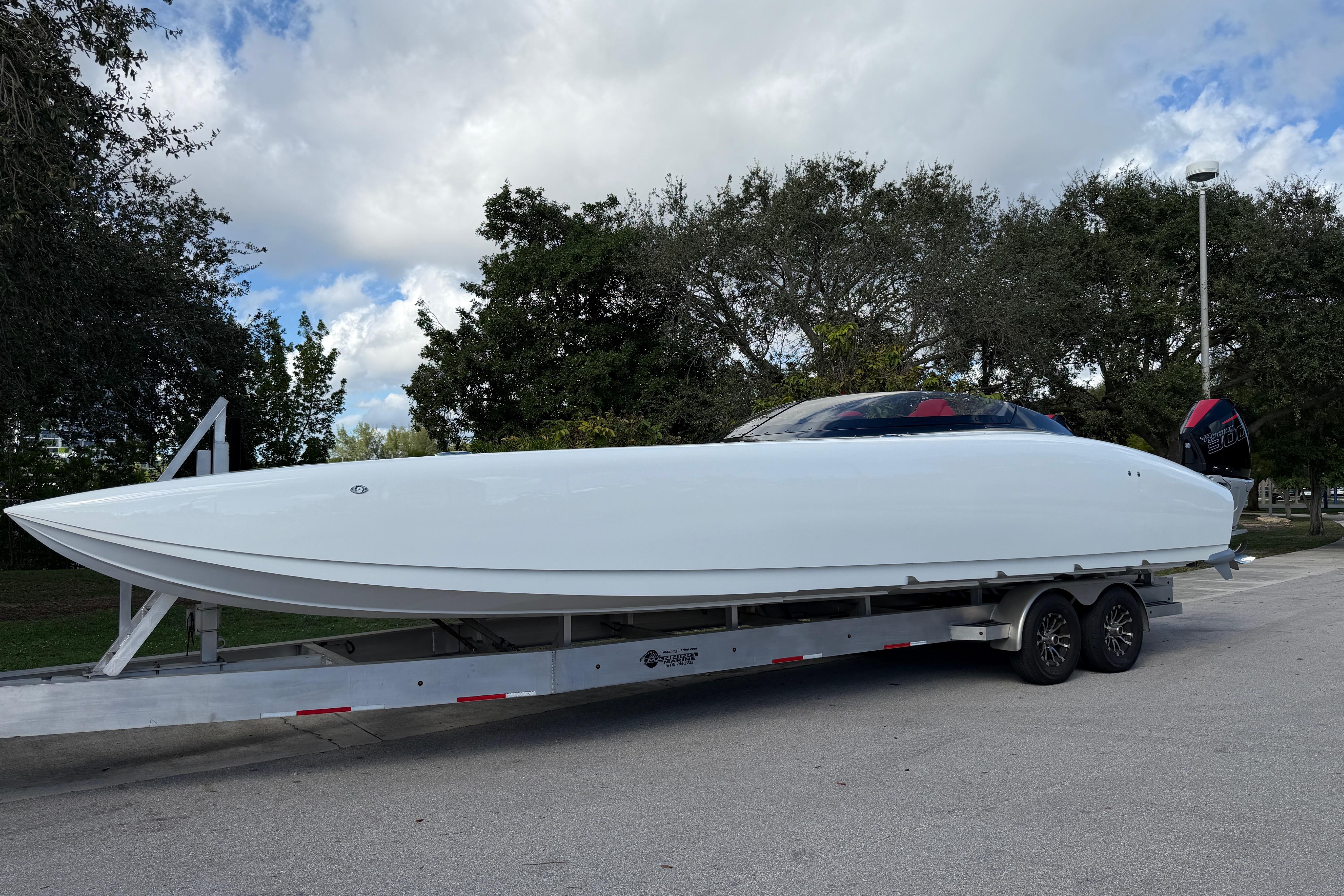 2022 Doug Wright 320 powerboat on trailer, parked outdoors under cloudy sky.