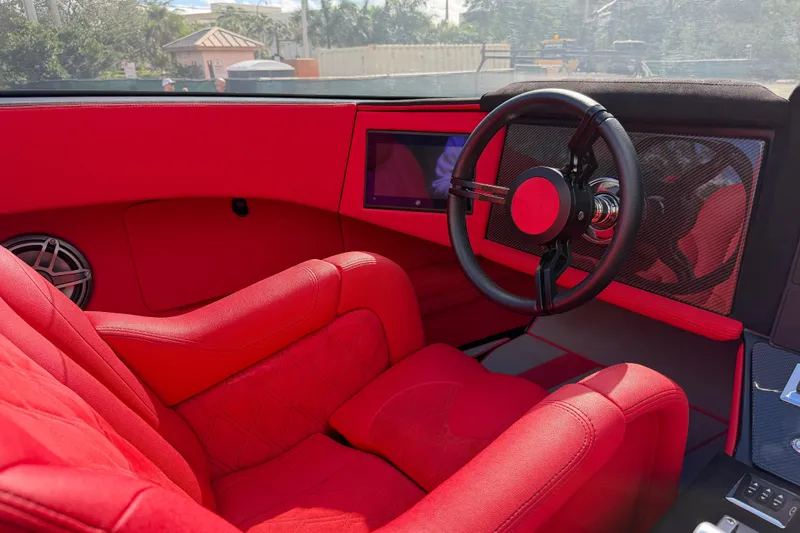  Yacht Photos Pics Red interior of a 2022 Doug Wright 320, featuring a sleek steering wheel and modern dashboard.