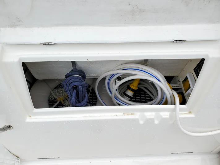  Yacht Photos Pics Storage compartment on a 2004 Cruisers Yachts 340 Express with coiled hoses and ropes.