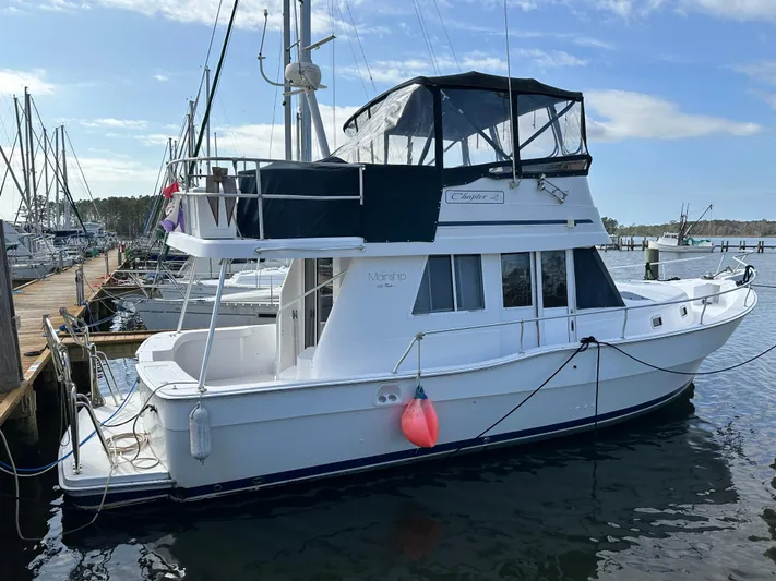 Chapter 2 Yacht Photos Pics 1998 Mainship 350 Trawler docked at marina, featuring upper deck and enclosed cabin.