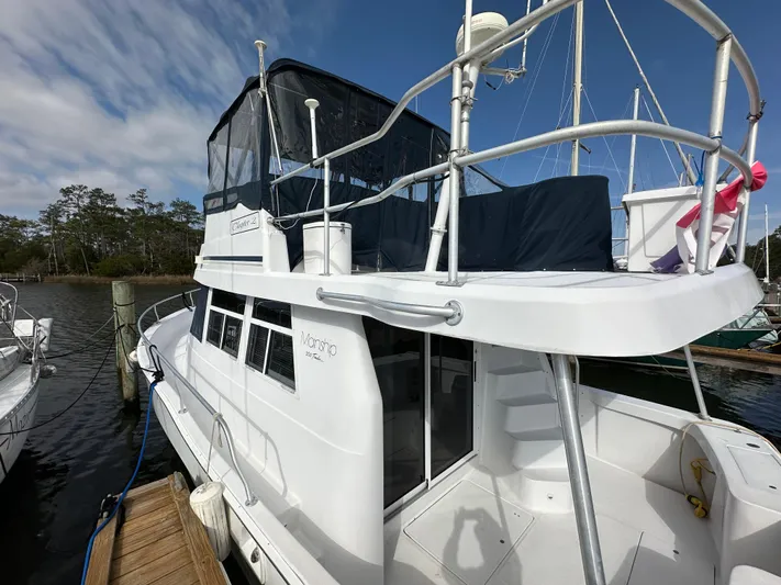Chapter 2 Yacht Photos Pics 1998 Mainship 350 Trawler docked, featuring upper deck and enclosed cabin.