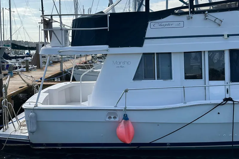 Chapter 2 Yacht Photos Pics 1998 Mainship 350 Trawler docked at marina with visible fender and windows.