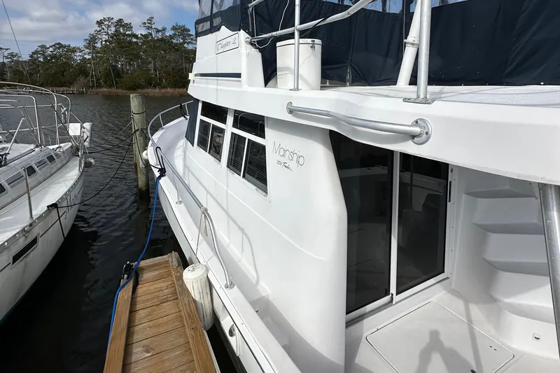Chapter 2 Yacht Photos Pics 1998 Mainship 350 Trawler docked, showcasing side view and entryway.