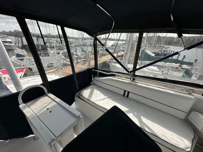 Chapter 2 Yacht Photos Pics 1998 Mainship 350 Trawler interior with white seating, marina view through windows.