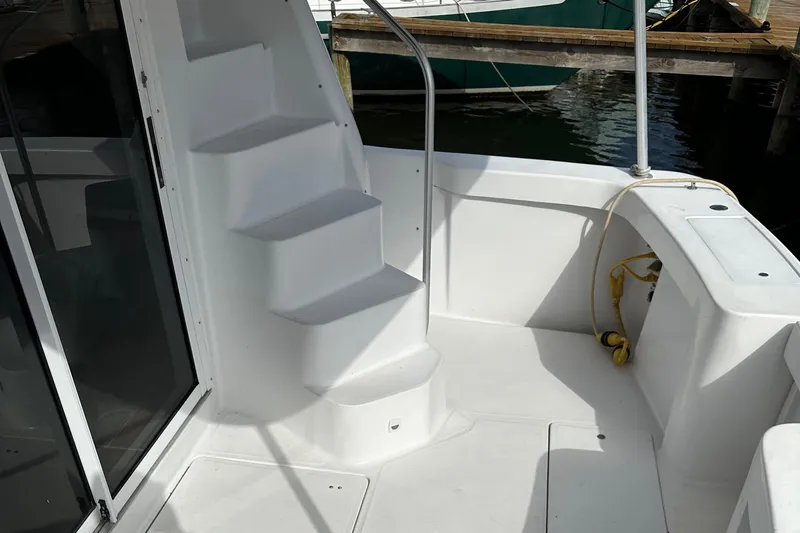 Chapter 2 Yacht Photos Pics 1998 Mainship 350 Trawler deck with stairs, docked at marina.
