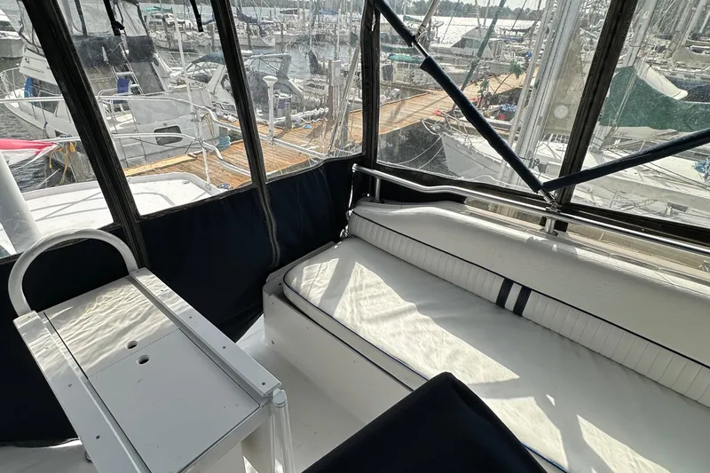 Chapter 2 Yacht Photos Pics 1998 Mainship 350 Trawler interior with seating and marina view.