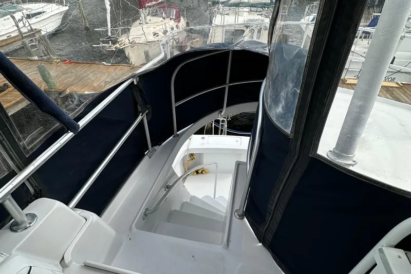 Chapter 2 Yacht Photos Pics 1998 Mainship 350 Trawler staircase with blue canvas enclosure at marina.