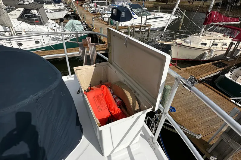 Chapter 2 Yacht Photos Pics 1998 Mainship 350 Trawler with open storage compartment, docked at marina.