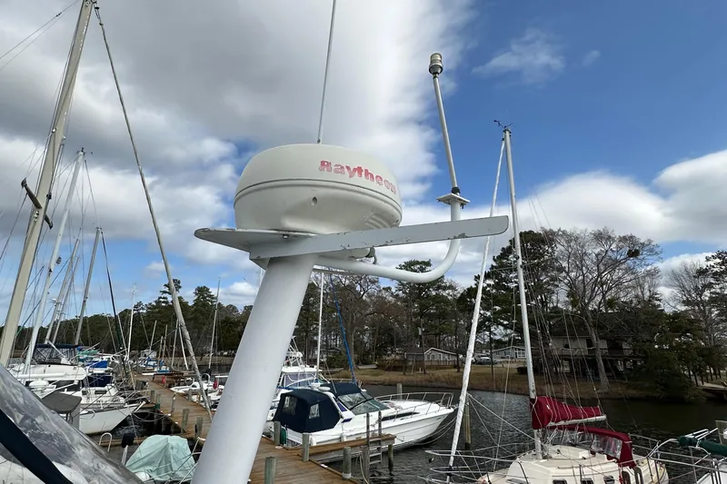 Chapter 2 Yacht Photos Pics 1998 Mainship 350 Trawler docked, featuring Raytheon radar, surrounded by sailboats under cloudy sky.